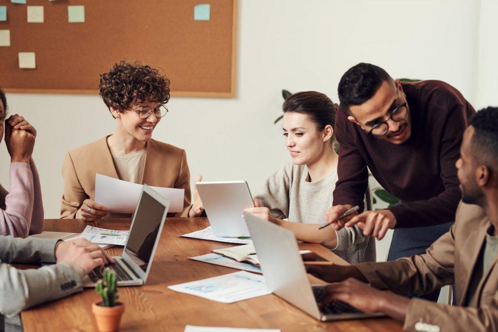 Pessoas numa mesa de trabalho trocando ideias. Intercâmbio de estudo e trabalho na Austrália.