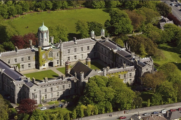 Visão aérea da Universidade de Galway, sua torre e a paisagem arborizada ao fundo