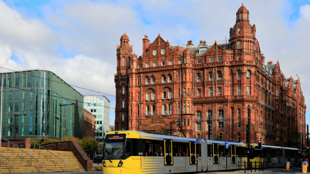 Estrutura de prédio com metrô passando à frente. Custo de vida em Manchester.