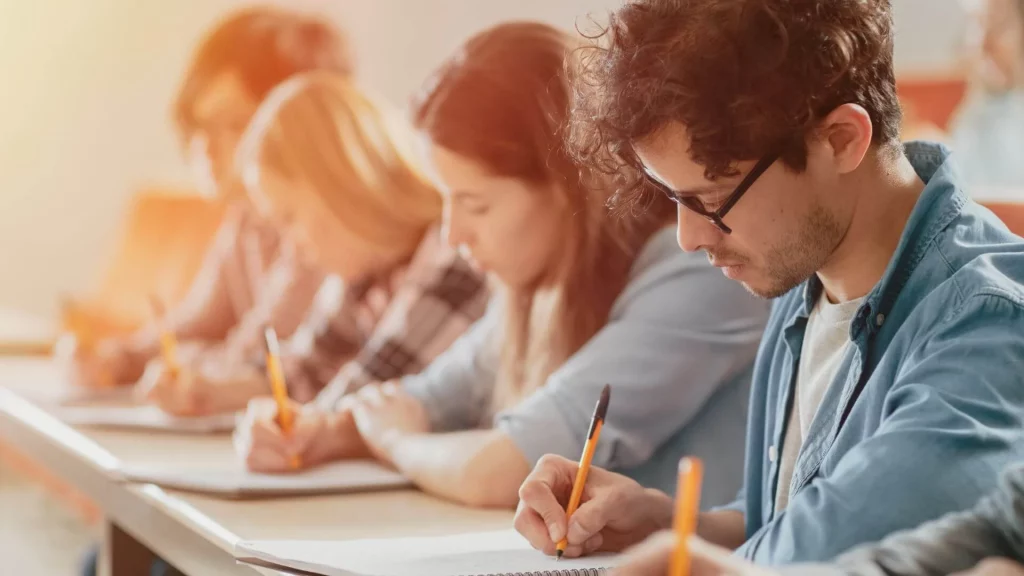 Estudantes fazendo um teste escrito em sala de aula